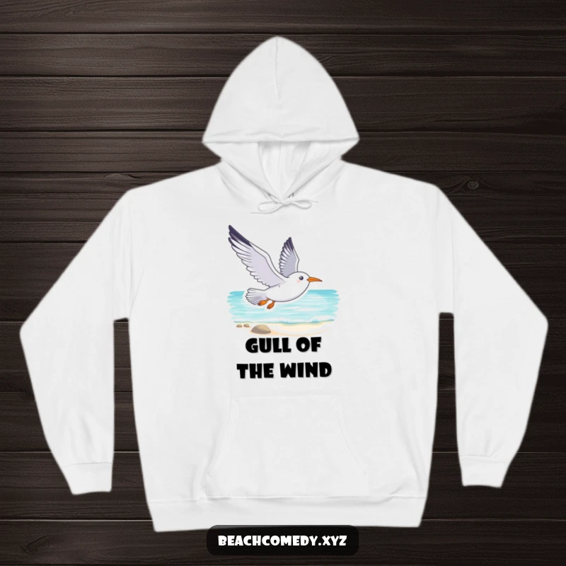 Funny seagull hoodie with a smiling seagull soaring gracefully above a tranquil beach, offering warmth and humorous coastal vibes.